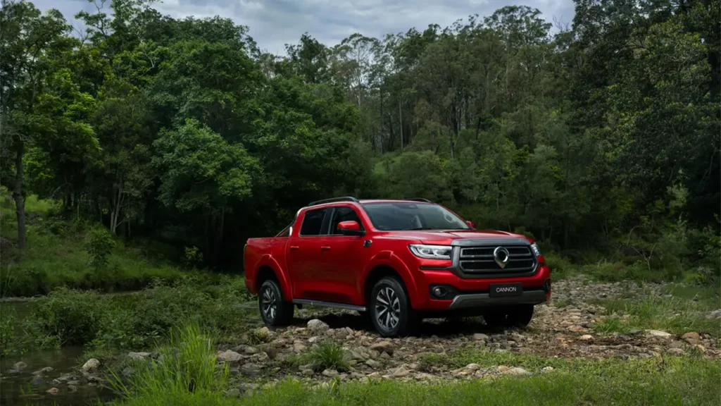 "Chinese cars for off-road performance: red GWM Cannon pickup truck driving through a rocky forest trail."