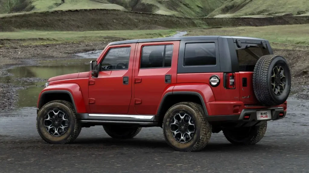 Red BAIC BJ40 Plus on a dirt road, rear view with muddy tires and "BJ40 Plus" badge.