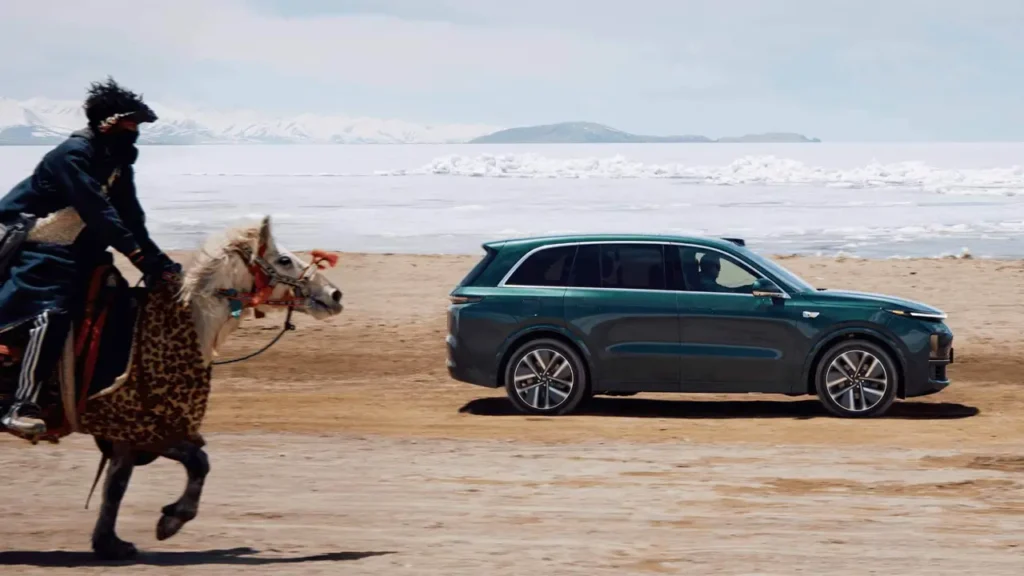 Li L8 hybrid SUV driving next to horse in open landscape